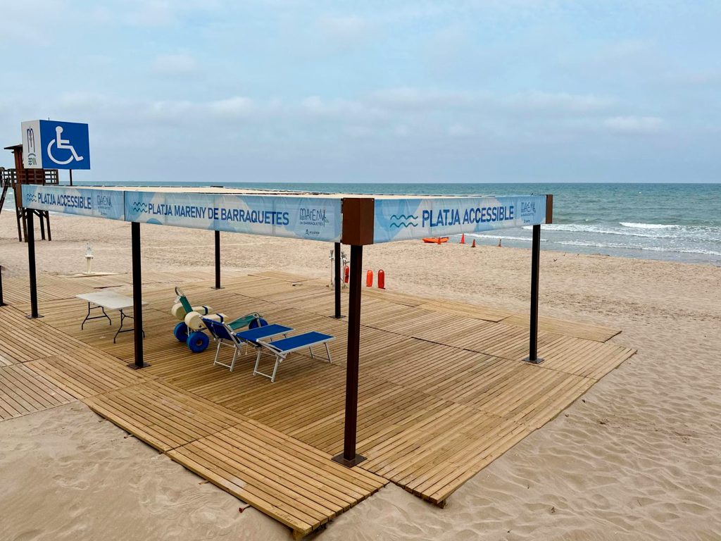 Pérgola de playa para espacio accesible con superficie de madera y toldo. 